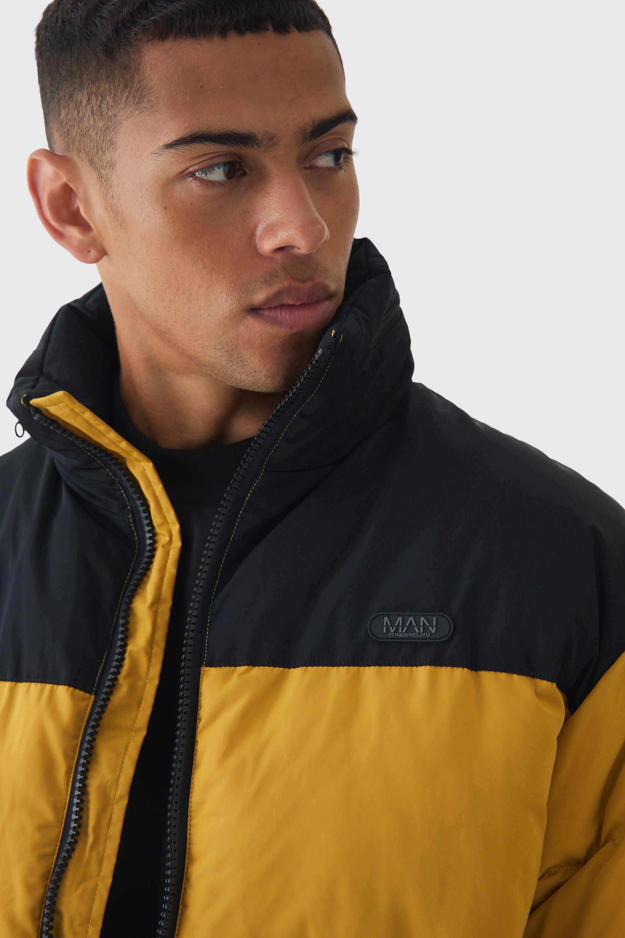 Cappotto piumino senape con etichetta Man a blocchi di colore e cappuccio nascosto
