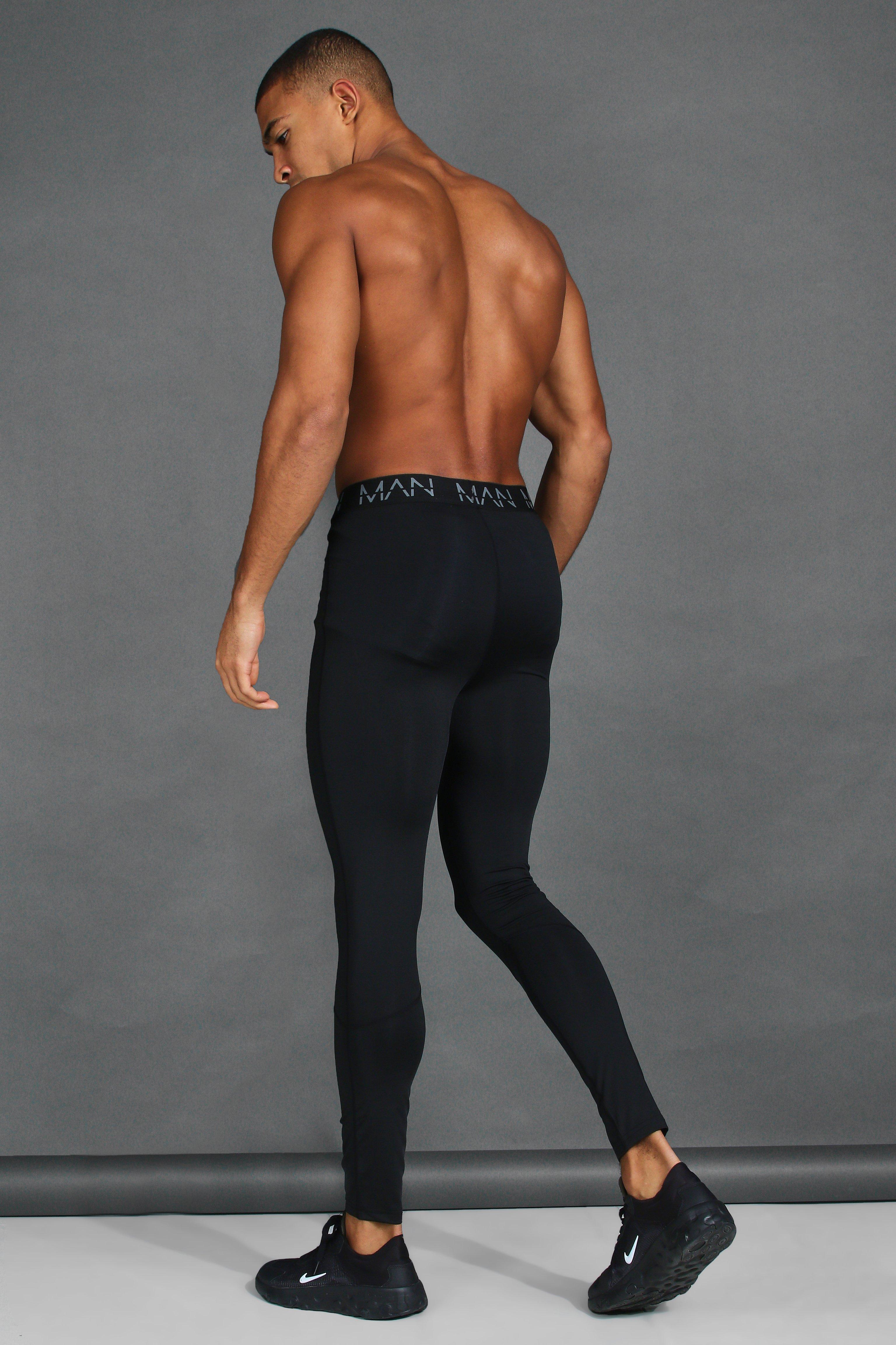 Muscular Man in Black Compression Sportswear on Gray Background