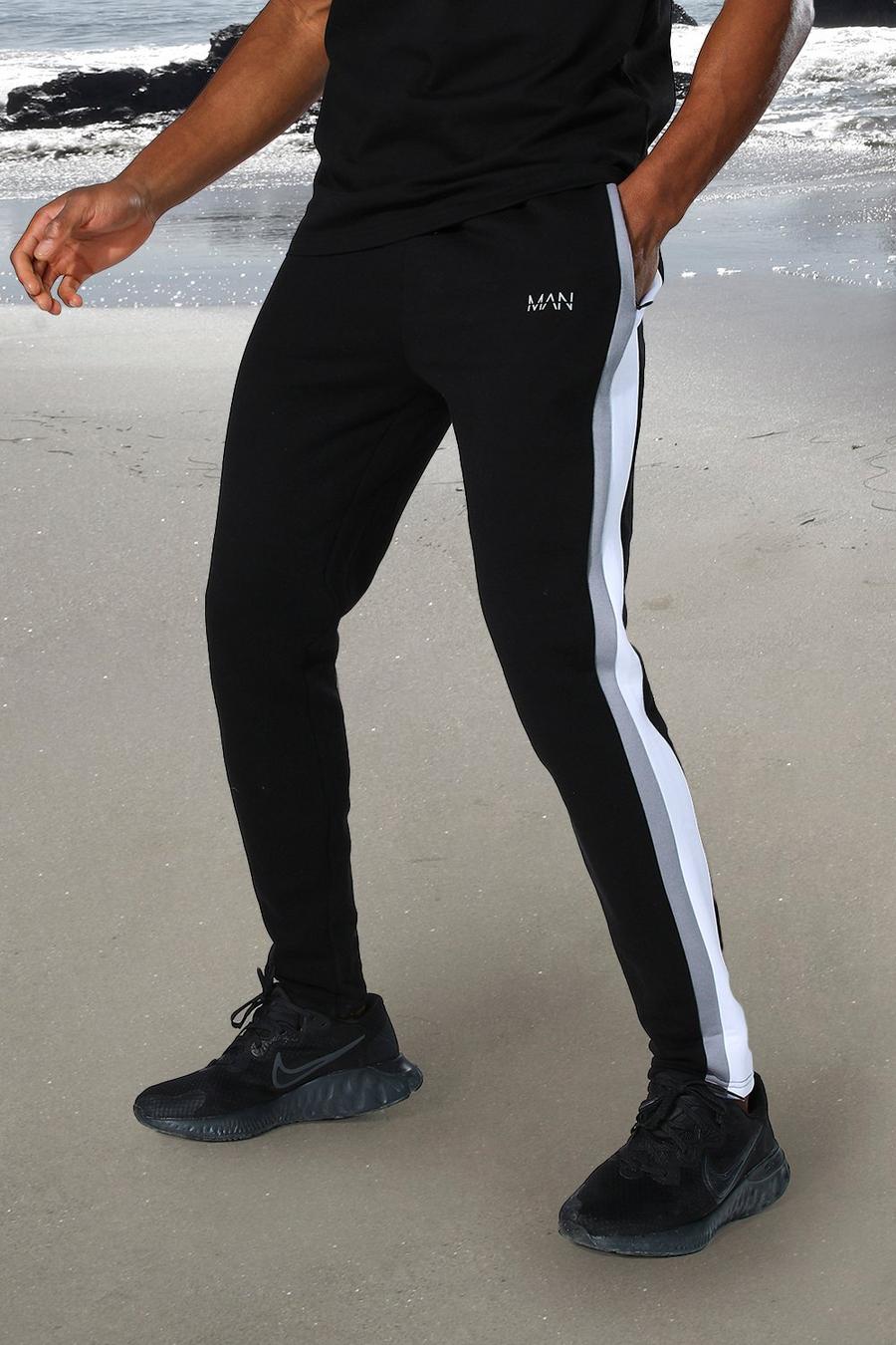 שחור מכנסי ריצה ספורטיביים בגזרת סקיני עם כיתוב MAN ופס בצד image number 1