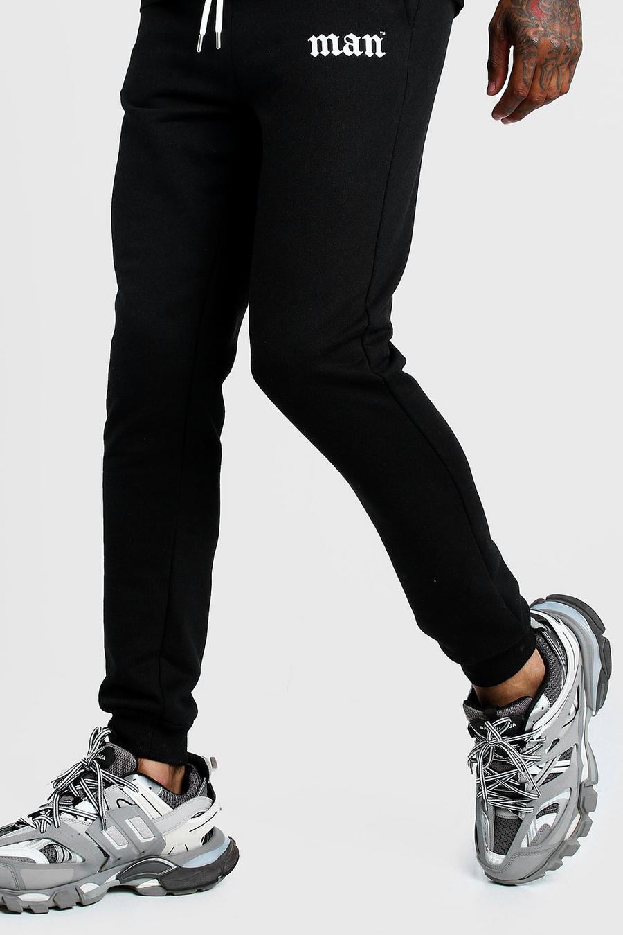Skinny Fit Jogginghose mit Gothic-MAN-Print auf dem Oberschenkel, Schwarz image number 1